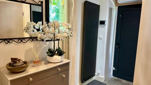 een badkamer met een spiegel en een dressoir met bloemen erop bij Meuble prestige in Nancy