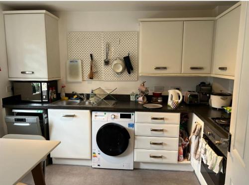 a kitchen with white cabinets and a washer at Bahram in Parkside