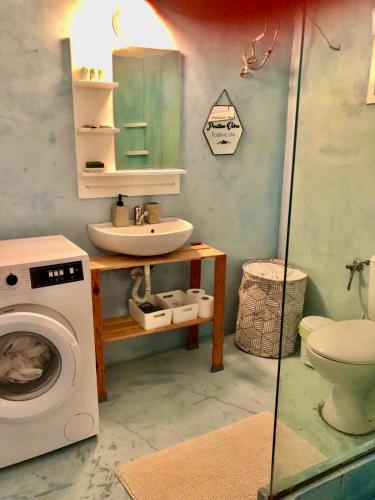 a bathroom with a washing machine and a sink at Ocean Eyes in Ipsos