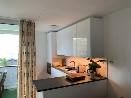 eine Küche mit weißen Schränken und einer Arbeitsplatte in der Unterkunft 4* + 5* Luxury Apartments in Sankt Gilgen