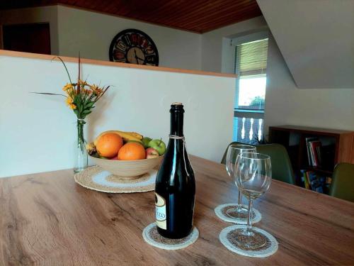 uma garrafa de vinho e dois copos numa mesa de madeira em Zelený apartmán Králiky em Králiky