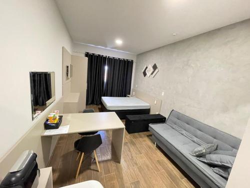 een woonkamer met een bank en een tafel bij Flat Aconchegante in Sorocaba