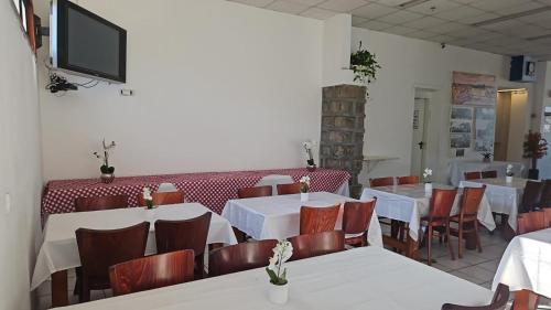 un restaurante con mesas y sillas y TV en la pared en Atara Hotel, en Tiberíades