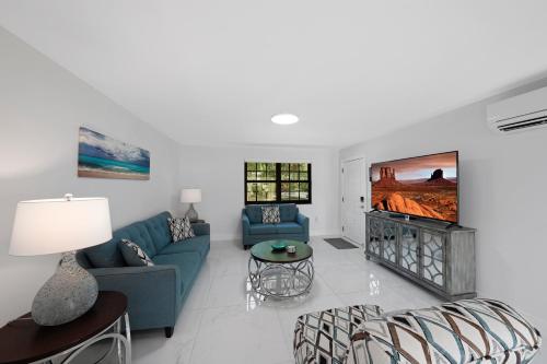 a living room with a blue couch and a tv at Dania Beach Unit 1 By Pmi in Dania Beach