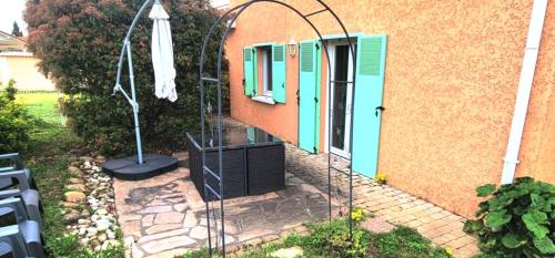 a building with an archway next to a house at Casa Papidou, Charmante Maison au calme in Jonage