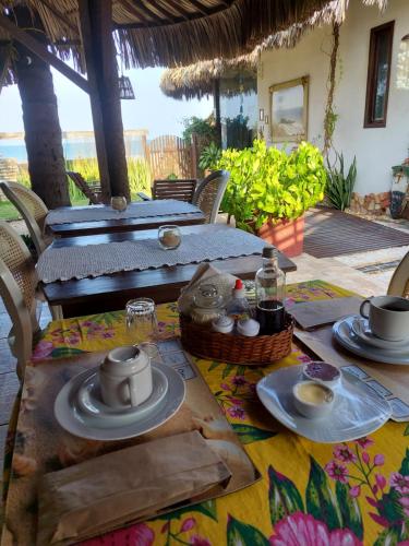 a table with plates and cups on top of it at Espaço Fateixa in Jericoacoara