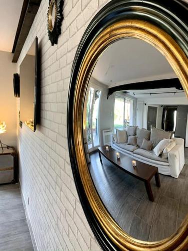 un miroir reflétant un salon avec un canapé blanc dans l'établissement Maison de ville spacieuse & cosy, à LʼIsle-sur-la-Sorgue