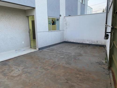 um quarto vazio com uma parede branca e um piso de betão em Apartamento terreo com quintal individual em Patos de Minas