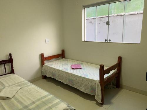 um quarto com 2 camas e uma janela em Apartamento terreo com quintal individual em Patos de Minas