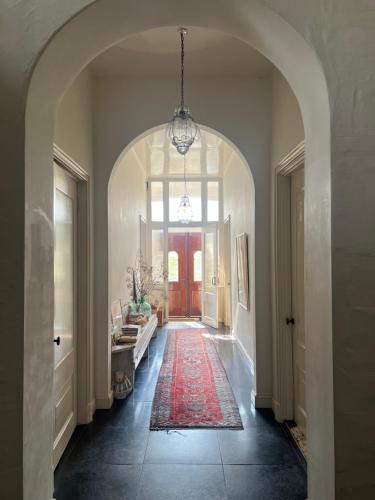 a hallway with an arched entry way with a red rug at Ark van Thesinge 