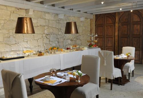 a dining room with tables and chairs and a stone wall at Delser Verona Manor House in Verona