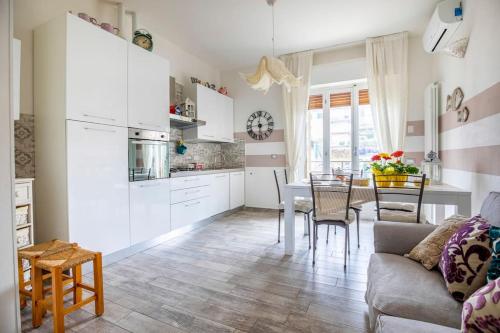 cocina y sala de estar con sofá y mesa en Annali Casa vacanze - Shabby style nella natura, en La Spezia