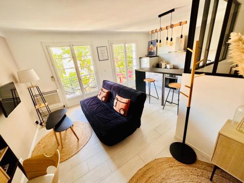 a living room with a couch and a kitchen at Chez Garance Saint-Tropez in Saint-Tropez
