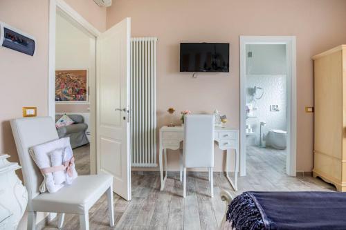 1 dormitorio con 1 cama y escritorio y 1 dormitorio con 1 cama en Annali Casa vacanze - Shabby style nella natura, en La Spezia