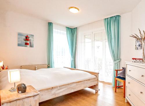 a bedroom with a large bed with blue curtains at Dünenblick Wohnung 05 in Boltenhagen