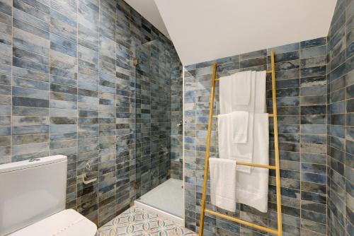 een badkamer met een toilet en een douche met blauwe tegels bij Villa Xique 11 in Monchique