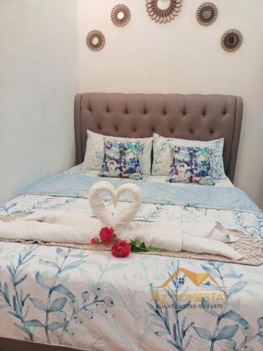 Una cama con un corazón hecho de toallas en AZ Homestay 1 en Kuantan