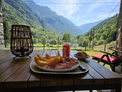 Verzasca: Casa Sonia في Frasco: طبق من الطعام فوق طاولة خشبية