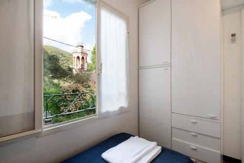 1 dormitorio con ventana y vistas a la torre en Beach Paradise - Cicerone, en Levanto