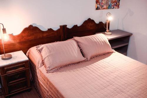 a bedroom with a bed with two night stands and two lamps at Apartamento pura vida no Parque Una com vaga de garagem. in Pelotas