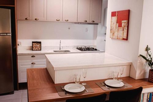 uma cozinha com uma mesa com dois pratos em Apartamento pura vida no Parque Una com vaga de garagem. em Pelotas