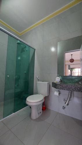 La salle de bains est pourvue de toilettes, d'une douche et d'un miroir. dans l'établissement Pousada Albuquerque, à Jericoacoara