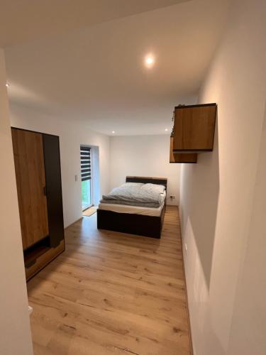 a bedroom with a bed and a wooden floor at Moderne 2 Zimmer-Ferienwohnung in Nörten-Hardenberg