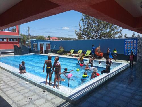 eine Gruppe von Menschen, die in einem Schwimmbad spielen in der Unterkunft Hotel Good Putt in Nakuru