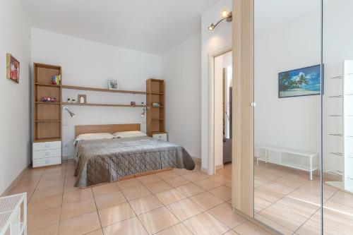 um quarto com uma cama e uma porta de vidro em Porta Maggiore Apartment em Bolonha