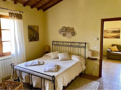 um quarto com uma cama com duas toalhas em Relais Poggio Del Melograno em Montecatini Val di Cecina