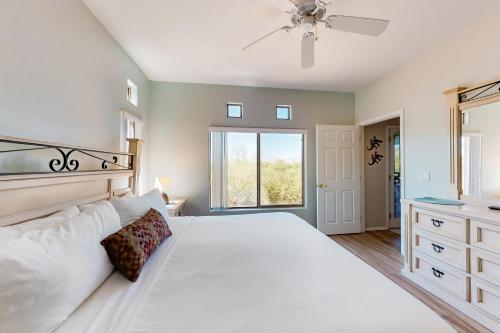 ein Schlafzimmer mit einem großen weißen Bett und einem Fenster in der Unterkunft Vistoso Resort Casita #126 in Tortolita