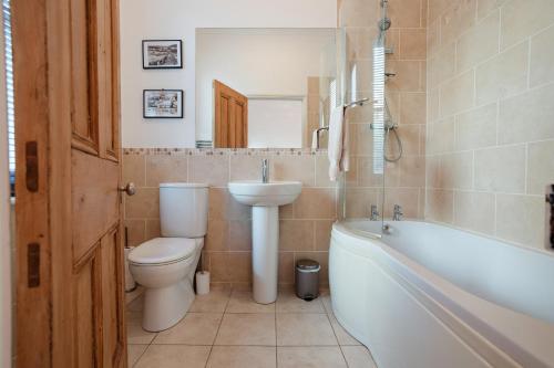 a bathroom with a toilet and a sink and a tub at Ventnor Views in Ventnor