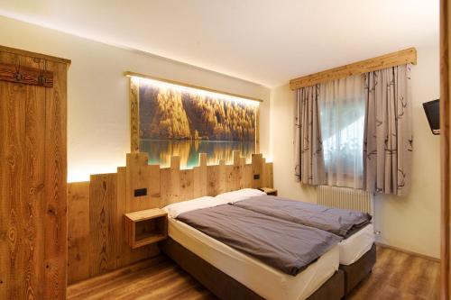 リヴィーニョにあるChalet Leur Gusja Golp Bilocaleのベッドと壁に絵が飾られた寝室