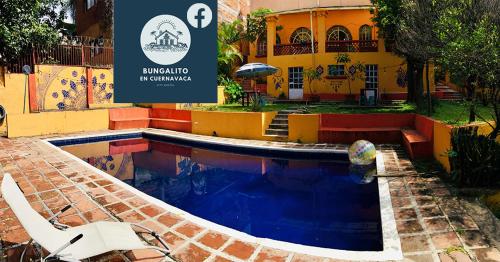 a swimming pool in front of a building with a sign at Bungalito en Cuernavaca in Cuernavaca