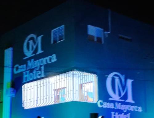 eine blaue Wand mit einem Gebäude mit einem Schild darauf in der Unterkunft Hotel Casa Mayorca in Maicao