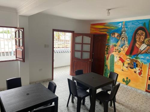 ein Zimmer mit einem Tisch und einem Gemälde an der Wand in der Unterkunft Hotel Casa Mayorca in Maicao