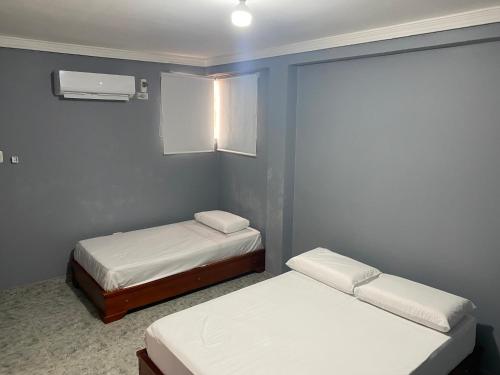 Zimmer mit 2 Betten und einem Fenster in der Unterkunft Hotel Casa Mayorca in Maicao