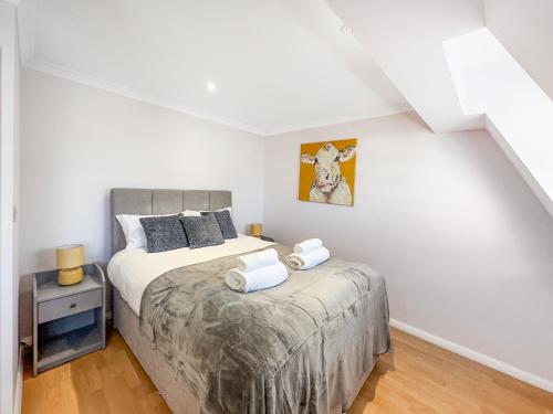 a bedroom with a large bed and a night stand at Serene 2BR Retreat in Bishop's Stortford in Bishops Stortford