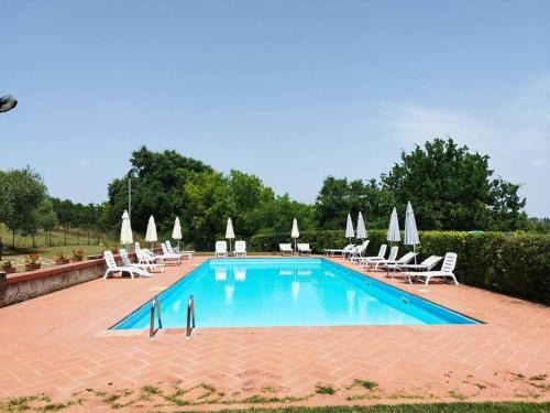 a swimming pool with chairs and umbrellas at Relax nella jacuzzi in Toscana in Colle Val D'Elsa