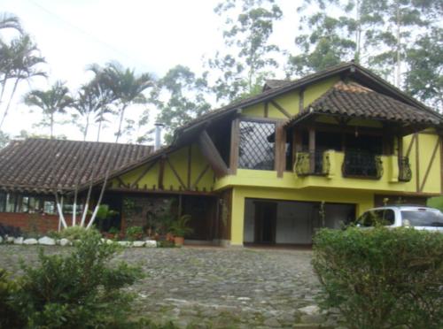 麥德林的住宿－Medellín Kimball's Appartments!，一座黄色的房子,前面有一辆汽车