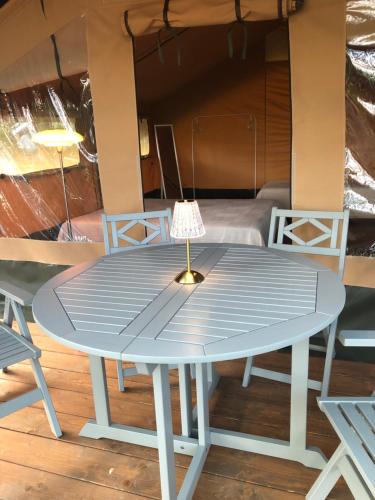 a blue table and chairs on a deck with a bed at AgriGlamping La Diaccia in Serravalle Pistoiese