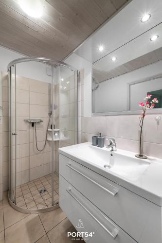 a bathroom with a shower and a sink and a mirror at Ferienhaus Meerblick Marina Wendtorf in Wendtorf