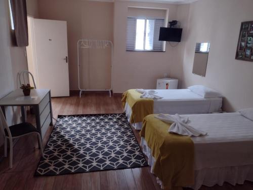 a hotel room with two beds and a television at Hotel Cidade Aventura in Socorro