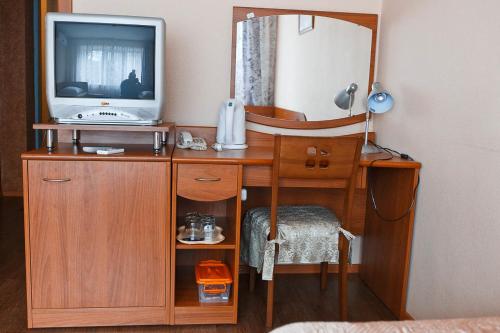 uma secretária de madeira com uma televisão e um espelho em Hotel ABA em Novokuznetsk