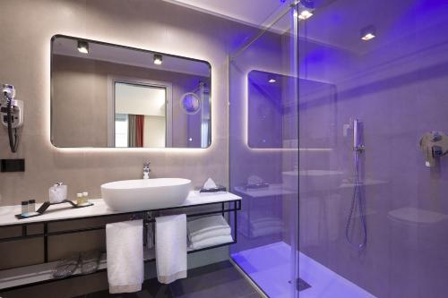 bagno con lavandino e doccia in vetro di iQ Hotel Firenze a Firenze