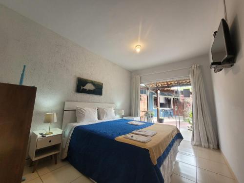 a bedroom with a blue bed and a window at Pousada Cielo Blu in Búzios
