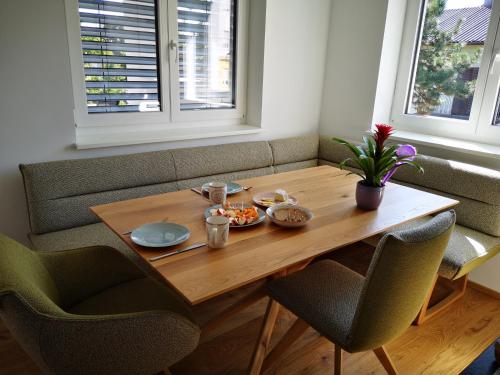 uma mesa de madeira com comida e duas cadeiras em Cosy Apartment next to the center of Graz em Graz