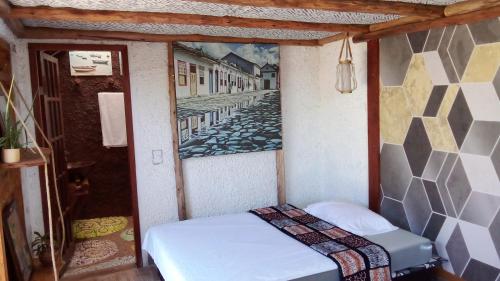 małe łóżko w pokoju z obrazem na ścianie w obiekcie Casa da Flor Amarela w mieście São Pedro da Aldeia