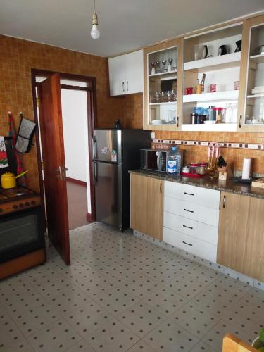 cocina con armarios blancos y nevera negra en Double Rooms en Nairobi