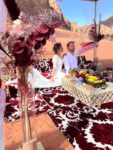 a man and a woman sitting at a table with flowers at Queen's Magic Camp in Disah